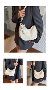 Detail view of the textured floral jacquard fabric on the white hobo bag with teddy charm