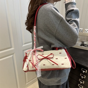 Red bow canvas shoulder bag with polka dots and ribbon-wrapped handle on a model