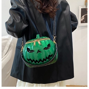 Detail of green glitter pumpkin crossbody bag with gold zippers worn by model