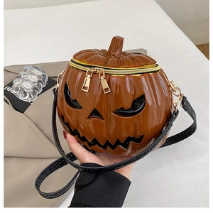 Detailed shot of pumpkin-shaped crossbody bag with glossy patent leather and gold zipper