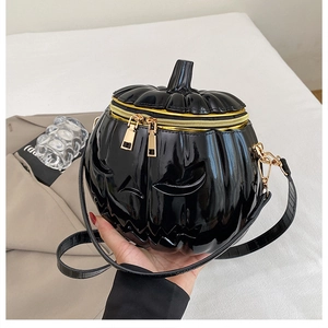 Detail of creative pumpkin-shaped crossbody bag featuring glossy finish and gold zipper