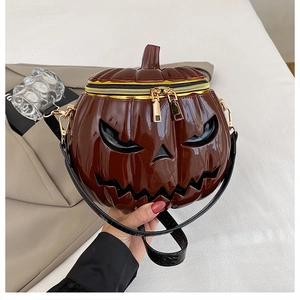 Detail showing high-gloss brown pumpkin bag with 3D镂空 classic ghost face and dual gold zippers