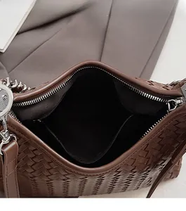 Top view detail of the woven leather handbag showing smooth zipper and interior capacity