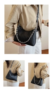 Detail of black woven leather hobo bag with silver chain strap and matte texture