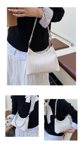 Detail of white woven hobo bag showing fine texture and silver chain leather strap