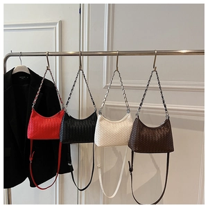 Detail of four woven leather crossbody bags in red, black, beige, and brown with chains