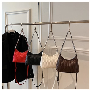 Showroom display of woven half-moon bags in red, black, white, and brown colors