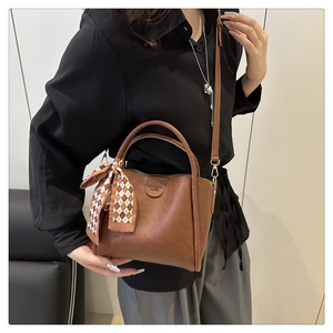 Dettaglio della borsa in pelle PU marrone opaco con foulard di seta e dettagli dorati
