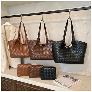 Detailed close-up of woven tote bag set in brown and black with matching zipper pouches