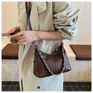 Detail of dark coffee woven hobo bag with leather texture and silver chain strap