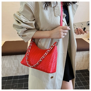 Detail of red woven leather crossbody bag with silver chain and half-moon silhouette