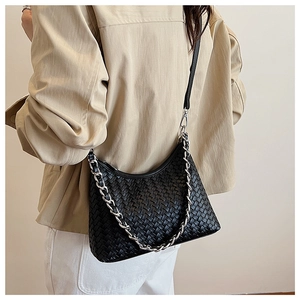 Detailed close-up of a black woven leather hobo bag with thick silver chain handle
