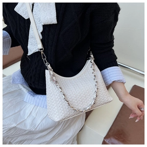 Close-up of white woven leather texture with silver chain strap and adjustable belt