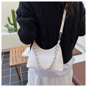 Close-up of white woven leather hobo bag featuring a decorative silver chain and shoulder strap