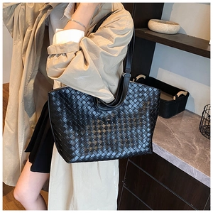 Detailed view of black woven leather tote bag featuring classic intrecciato craftsmanship