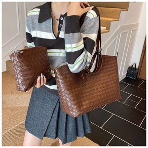 Detailed view of brown woven tote bag with matching zippered pouch on a fashion model