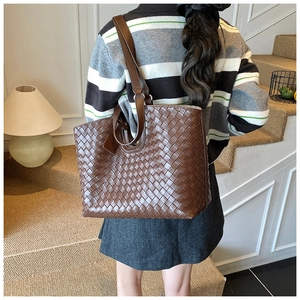 Close-up of brown woven leather tote bag shown on model for a stylish daily commute