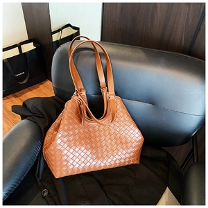 Detailed close-up of the caramel woven leather texture on this large tote bag for women