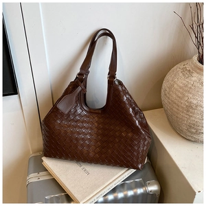 Close-up of deep brown woven tote bag with Intrecciato texture and leather handle