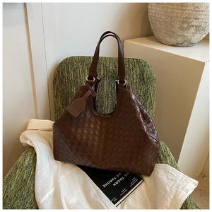 Macro view of dark brown leather woven texture and hobo handle on a vintage tote bag