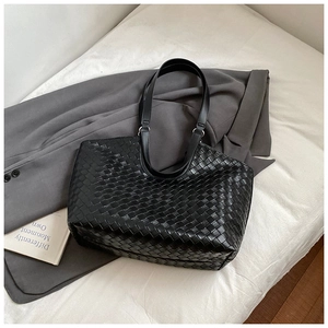 Detail of black woven tote bag with Intrecciato pattern and large capacity for commuting
