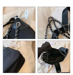 Detail view of black chain bag showing inner zipper pocket and metallic strap texture