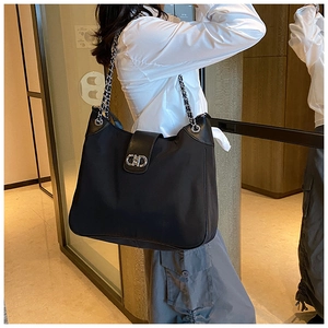 Detailed shot of large black tote bag featuring silver chain strap and CD metal buckle