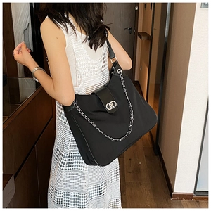 Detail of black soft leather tote with silver chain strap and metal swivel lock closure