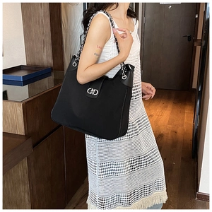 Detail of black glossy leather tote bag featuring silver chain and metal Gancini buckle