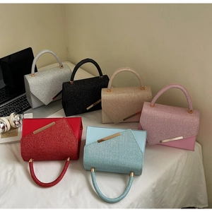 Top view of sparkling sequined handbags in six vibrant colors on a white fabric surface