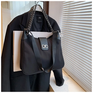 Close-up of black soft leather tote with stylish metal chain and CD clasp detail