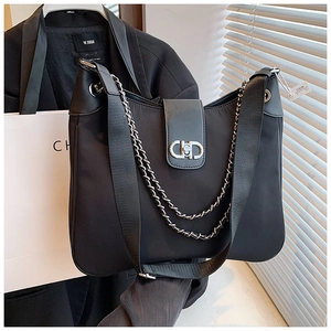 Close-up of black nylon shoulder bag with silver chain decor and metal buckle detail