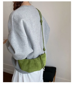 Détail du sac croissant vert sauge avec texture en daim et bandoulière nouée