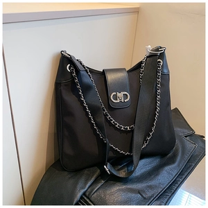 Close-up of the silver CD metal clasp and chain detail on the black soft tote bag