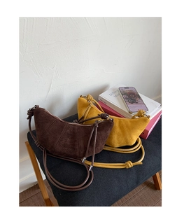 Gros plan de sacs demi-lune en daim mat marron et moutarde avec nœuds décoratifs