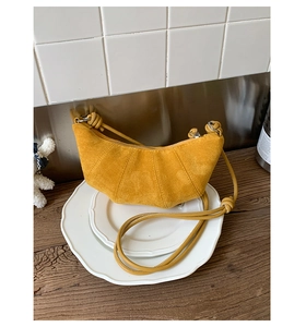 Détail du sac hobo jaune en forme de croissant avec texture mate et bandoulière nouée