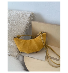 Détail du sac croissant jaune montrant la texture daim et les coutures verticales