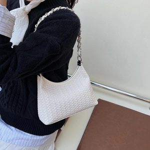 White woven leather shoulder bag with silver chain strap shown on a model