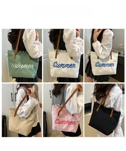 Détail de sacs fourre-tout en toile colorés avec broderie d'été et bords à franges