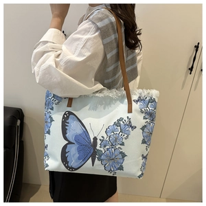 Detail of the blue butterfly print canvas tote bag with trendy white frayed fringe edges