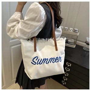 Détail du cabas en toile blanche avec broderie Summer, franges et bandoulière en cuir