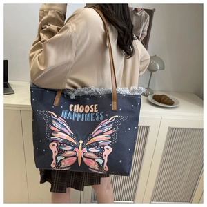 Detail of blue denim bucket bag with colorful butterfly print and Choose Happiness text