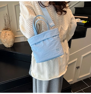 Sac seau en toile bleu clair avec logo RAH TOP porté à l'épaule en intérieur