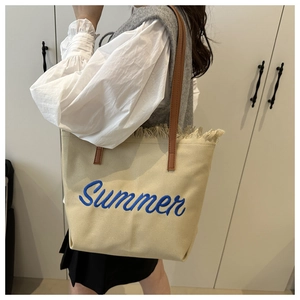 Détail du sac fourre-tout en toile avec franges en paille et broderie Summer bleue
