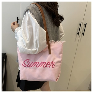 Close-up of pink canvas tote bag with Summer embroidery and stylish fringe detail