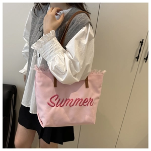 Détail du cabas en toile rose avec broderie Summer et bords à franges souples