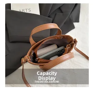 Detail view of the caramel leather bucket bag interior showing capacity for phone and wallet