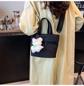 Détail du sac seau noir en nylon Oxford avec charm ours et logo embossé RAETOP