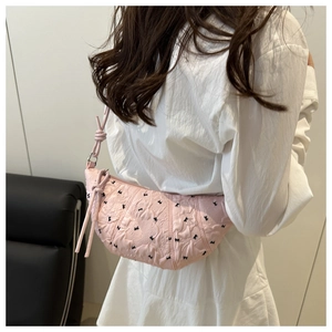 Pink crescent dumpling bag with pleated texture and black bow embroidery detail