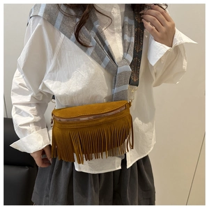 Détail du sac banane en daim jaune gingembre avec longues franges et sangle ethnique